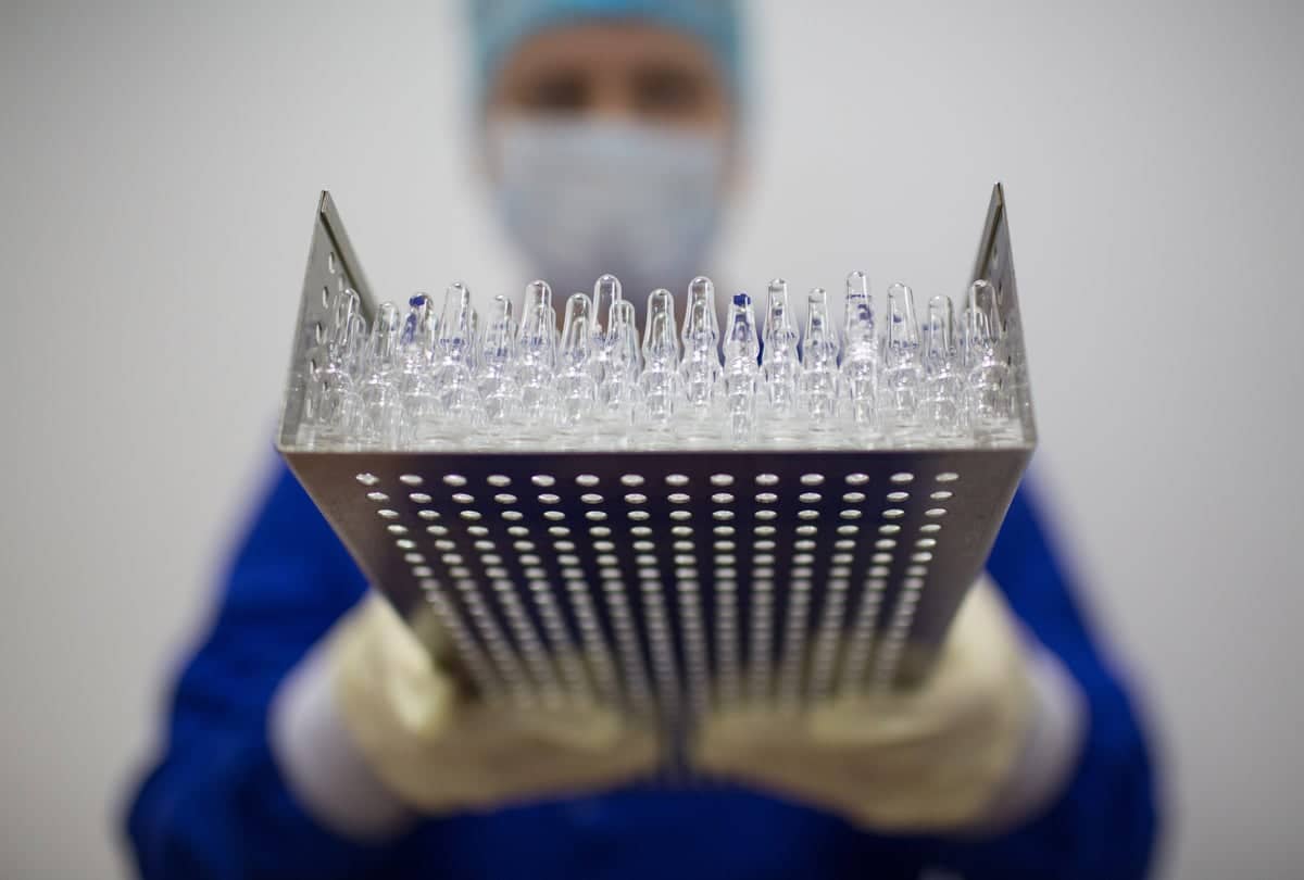 A-lab-worker-holds-a-tray-containing-unlabeled-vaccine-bottles-gayZ8s.jpg