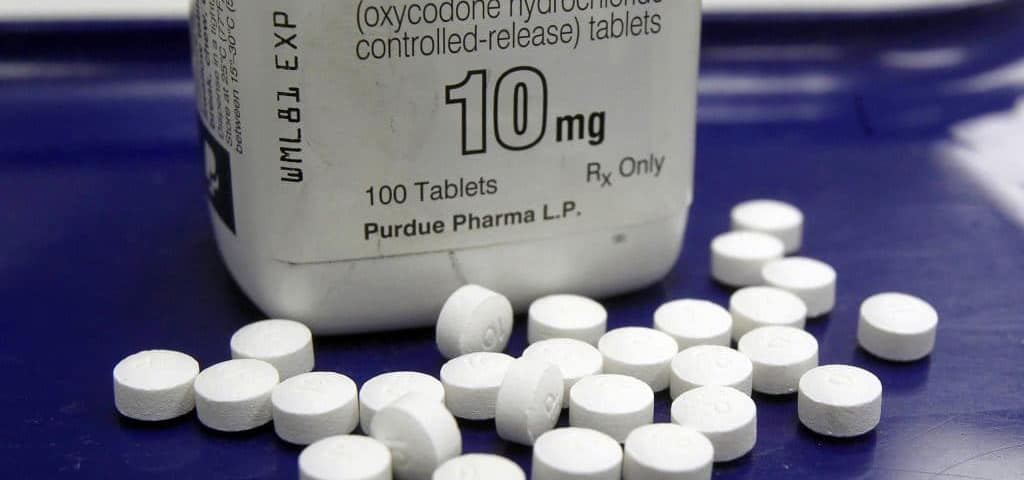 An OxyContin bottle with pills scattered around.