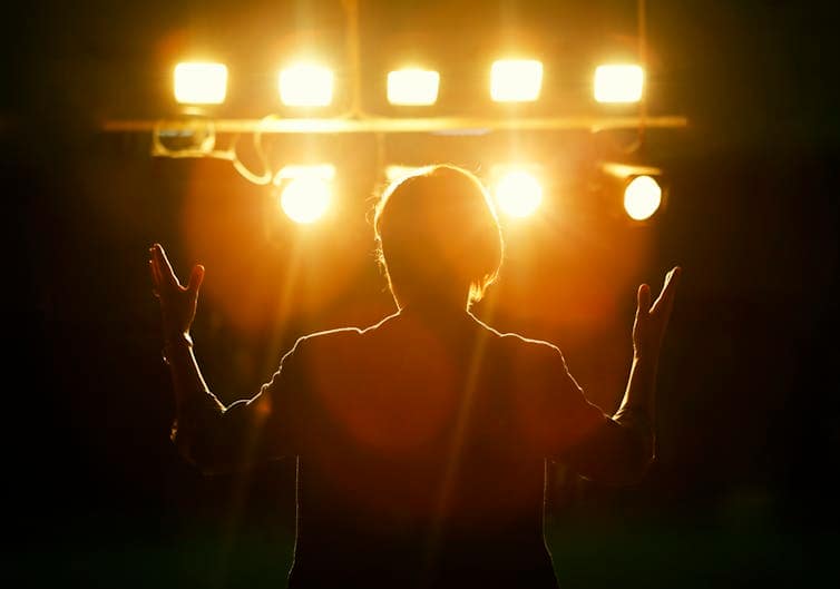 view behind person on stage with spotlights aimed at them