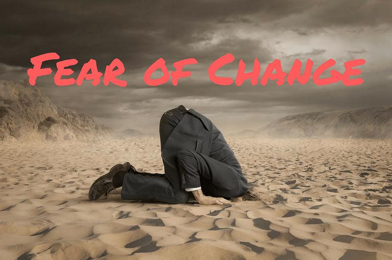 "Fear of Change" in red text over a picture of a man sticking his head in the sand.
