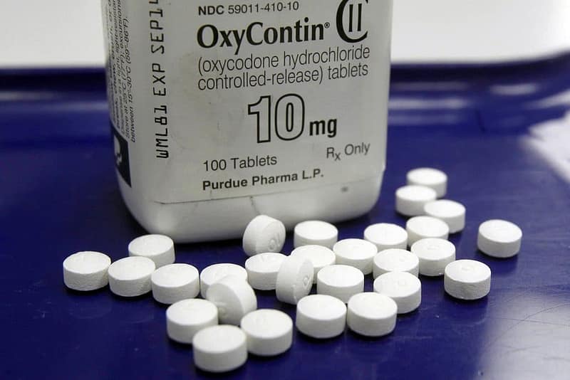 An OxyContin bottle with pills scattered around.